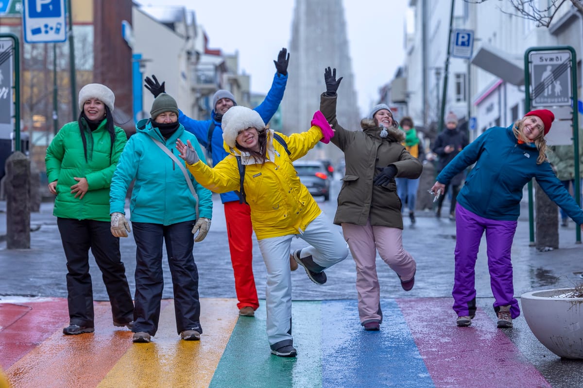 Viajeros en la calle del arcoíris de Reikiavik con la Hallgrímskirkja detrás